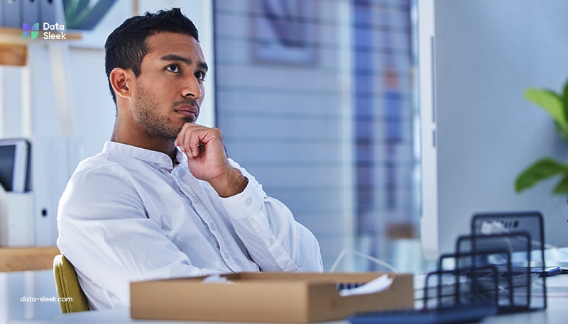 Man contemplating complex data management problems in blue minimalist office